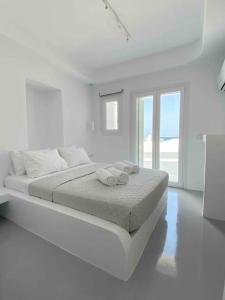 1 dormitorio blanco con 1 cama con 2 toallas en 31 Seafront Apartment, en Kampos