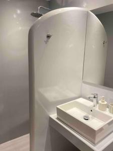 Baño blanco con lavabo y espejo en 31 Seafront Apartment, en Kampos