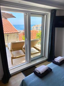 a bedroom with a large window with a view of the ocean at Sunset over the Dubrovnik's Old Town in Dubrovnik