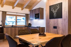 a dining room with a wooden table and chairs at Piciulei Pitl in Selva di Val Gardena