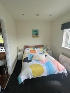 een slaapkamer met een bed met een kleurrijk dekbed bij Smythe Cottage in Kirkistown