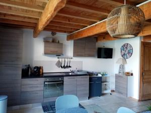 uma cozinha com tectos e armários de madeira em Gite du Piboulet em Les Granges-Gontardes