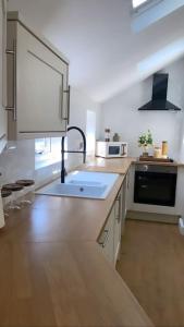 a large kitchen with a sink and a microwave at Churchview Apartments in Seaham