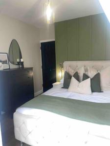 a bedroom with a large bed and a mirror at Churchview Apartments in Seaham