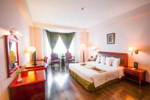 a hotel room with a bed and a table and chairs at Phnom Penh Hotel in Phnom Penh