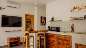 a kitchen with a counter and a tv on the wall at CDM Villas Kiwengwa in Kiwengwa