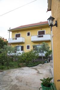 ein gelbes Apartmenthaus mit einer Einfahrt davor in der Unterkunft Apartment Lavanda in Zadar