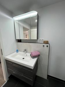 a bathroom with a sink and a mirror at Küstenzauber in Schönhagen +11 photos