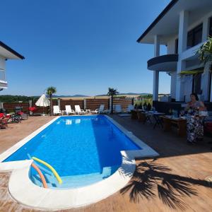una donna in piedi accanto a una piscina di Captain Niko Apartments a Burgas