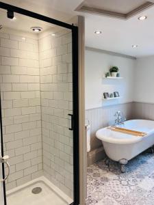 a bathroom with a bath tub and a sink and a bath tub at Little Pilgrims Retreat in St Dunstans, Canterbury in Kent