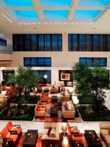 un gran vestíbulo con sofás, mesas y árboles en The Ritz-Carlton Beijing, Financial Street, en Beijing