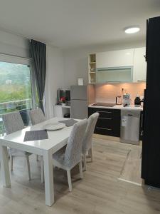 een keuken met een witte tafel en stoelen in een kamer bij Nahorevska vikendica in Sarajevo