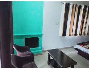 een woonkamer met stoelen en een tafel en een bank bij Green Heaven Resort , Chakrata in Chakrata