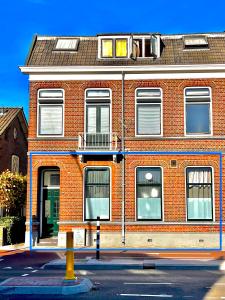 a red brick building with a balcony on top of it at Residentie de Eikhof in Hengelo