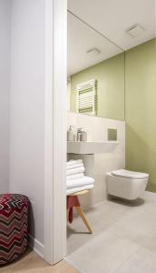 ein Badezimmer mit einem WC, einem Waschbecken und einem Spiegel in der Unterkunft Shades of Grey 124 in Bukarest
