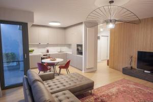ein Wohnzimmer mit einem Sofa und einem Tisch sowie eine Küche in der Unterkunft Shades of Grey 124 in Bukarest