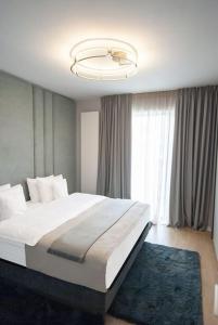 ein Schlafzimmer mit einem großen Bett und einem Kronleuchter in der Unterkunft Shades of Grey 124 in Bukarest