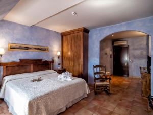 a bedroom with a bed and a chair at Hotel Doña Manuela in Daimiel