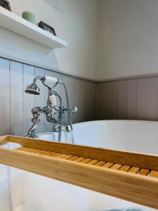 a bath tub with a faucet in a bathroom at Little Pilgrims Retreat in St Dunstans, Canterbury in Kent