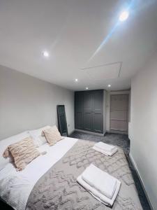 ein Schlafzimmer mit einem großen weißen Bett mit Handtüchern darauf in der Unterkunft Little Pilgrims Retreat in St Dunstans, Canterbury in Kent