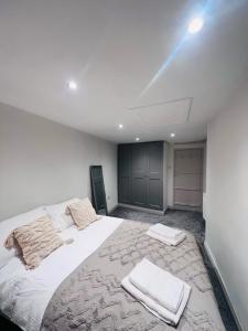 a bedroom with a large white bed with towels on it at Little Pilgrims Retreat in St Dunstans, Canterbury in Kent