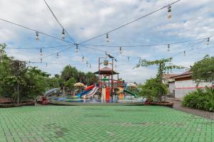 un parque acuático con un tobogán y un parque infantil en Urbanview Hotel Tropical Ketapang by RedDoorz, en Karawang