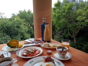 a table with plates of food and a bottle of orange juice at Estancia en plena naturaleza-Andrea in Sotogrande