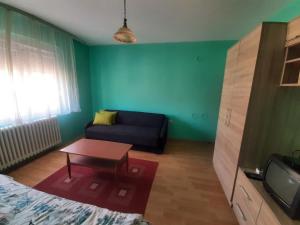 a living room with a couch and a table at City Park Rooms in Vranje