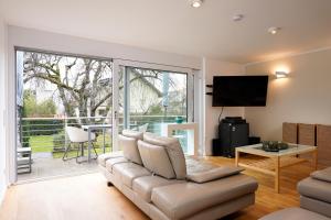 a living room with a couch and a large window at Design Apartment in Eppelheim in Eppelheim