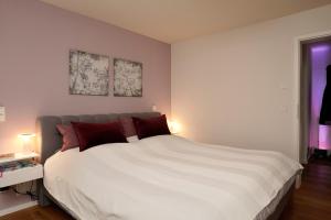 a bedroom with a large white bed with red pillows at Design Apartment in Eppelheim in Eppelheim
