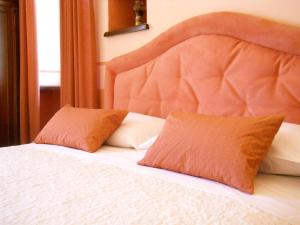 a bed with two orange pillows on top of it at Tenuta Calabiana in Diano dʼAlba