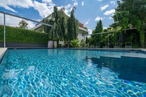 uma piscina com água azul em frente a uma casa em goldfinger + suites em Lana