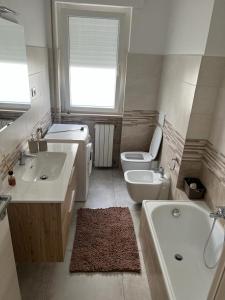 uma casa de banho com 2 lavatórios, uma banheira e um WC. em Roby Seahouse em Fossacesia