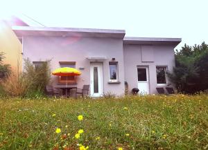 uma casa com uma mesa com um guarda-chuva amarelo em Bienvenus chez nous em Rixheim