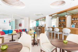 restauracja ze stołami i krzesłami oraz bar w obiekcie Plaza Santa Ponsa Boutique - Adults Only. w miejscowości Santa Ponsa