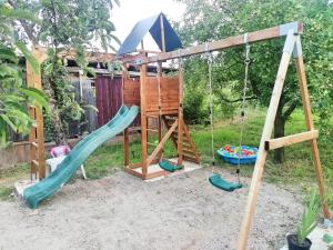 um parque infantil com um baloiço e um baloiço em Casa Noastră em Cricău