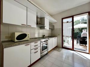 Cassero的住宿－[Idromassaggio] Relax, wi-fi, bbq & parcheggio，厨房配有白色橱柜和微波炉