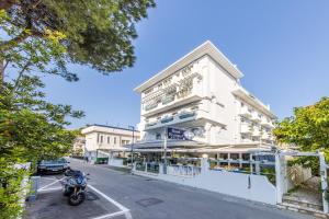 un bâtiment blanc avec une moto garée devant lui dans l'établissement Hotel Diamond, à Riccione