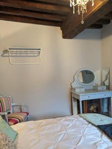 um quarto com uma cama, um espelho e uma cadeira em Chez Nick et Martine suite privative em Palinges