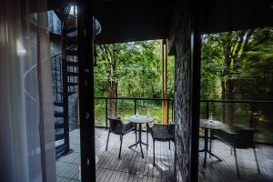 - un balcon avec deux tables et des chaises sur une terrasse couverte dans l'établissement Green Apartments Wilcza, à Karpacz