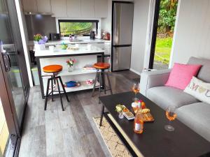 a kitchen and living room with a couch and a table at Secluded, private rural retreat mins from Warkworth -"Avondale" Minihouse in Warkworth