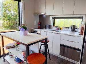a kitchen with white cabinets and a counter top at Secluded, private rural retreat mins from Warkworth -"Avondale" Minihouse in Warkworth