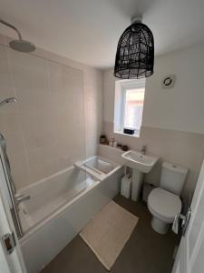 a bathroom with a tub and a toilet and a sink at Durham Homestay in Sacriston