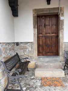 a bench in front of a building with a door at El Refugio del Busgosu in Pen