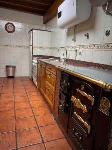 a kitchen with an oven and a sink in it at El Refugio del Busgosu in Pen