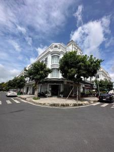 RUBY HOTEL في Tây Ninh: مبنى ابيض كبير امامه اشجار