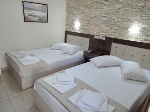 a hotel room with two beds with towels on them at Hotel Villa Pigasos in Paralia Katerinis