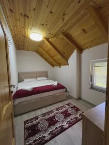 a bedroom with a bed and a wooden ceiling at Guesthouse Gezim Selimaj in Valbonë