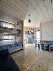 a living room with a bed and a dining room at Ventspils Podnieki in Ventspils