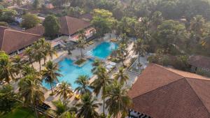 una vista aérea de una piscina del complejo con palmeras en Novotel Goa Dona Sylvia Resort, en Cavelossim